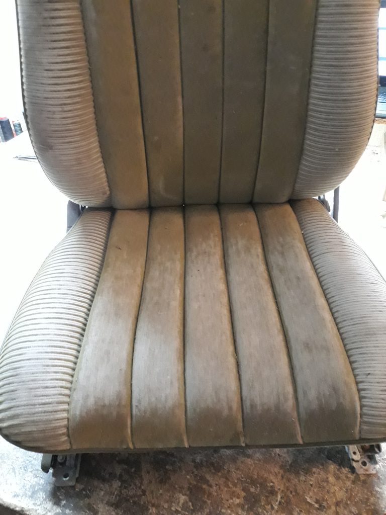 Fotel samochodowy retro z licznymi przetarciami